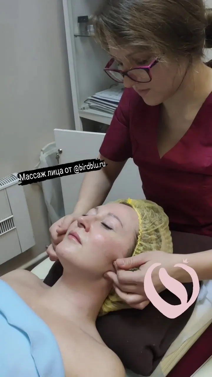 Женщина на приёме у массажиста, специалист делает массаж лица и шеи в клинике