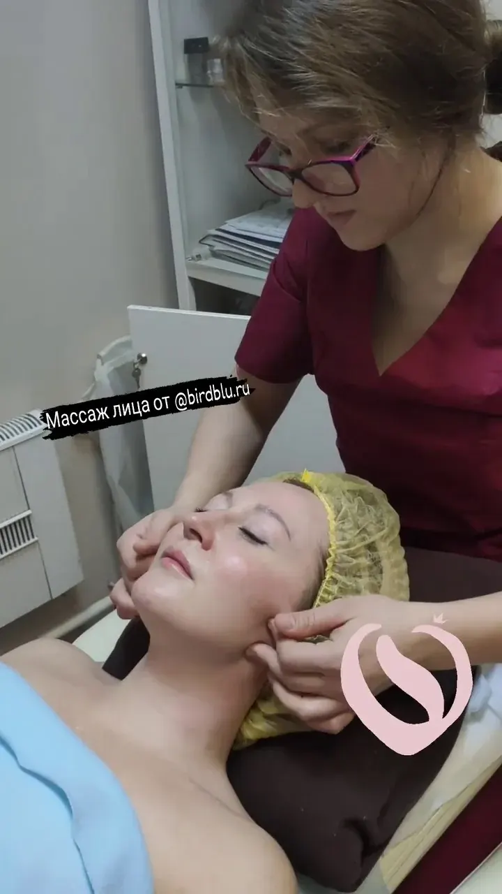 Женщина получает массаж лица и шеи в клинике, специалист в медицинской форме, надпись «Массаж лица от @birdblu.ru