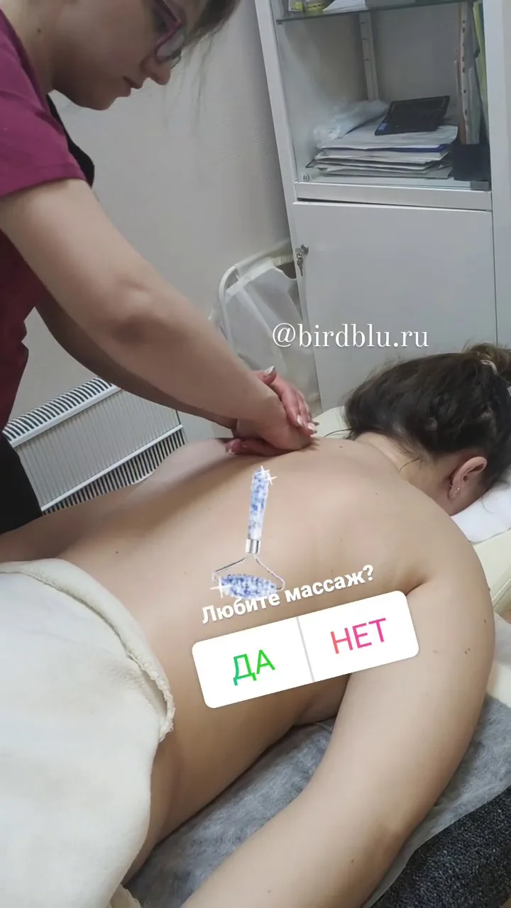 Массажист делает расслабляющий массаж верхней части спины клиенту